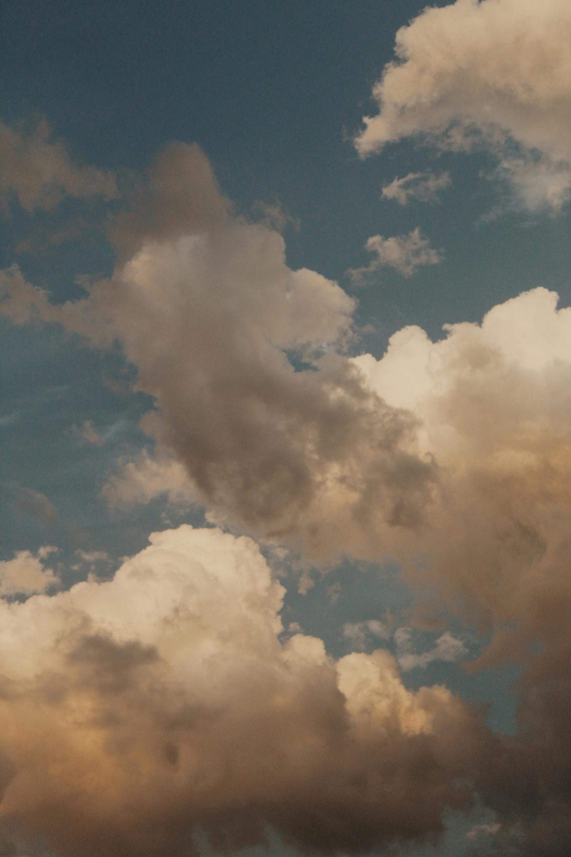 Captivating view of a dramatic cloudscape with varied lighting and textures against a blue sky.